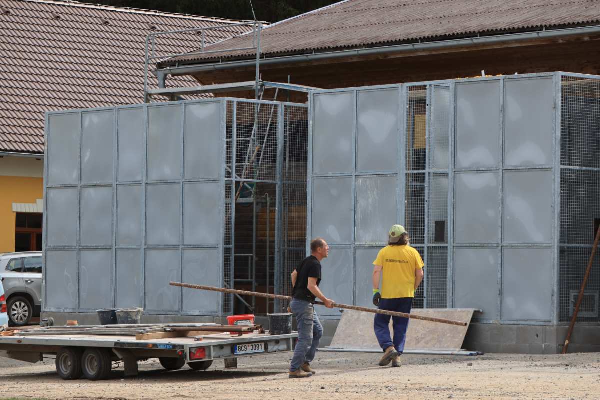 Stavební práce v záchranné stanici Klášterec, dělníci manipulují s materiálem při rekonstrukci.